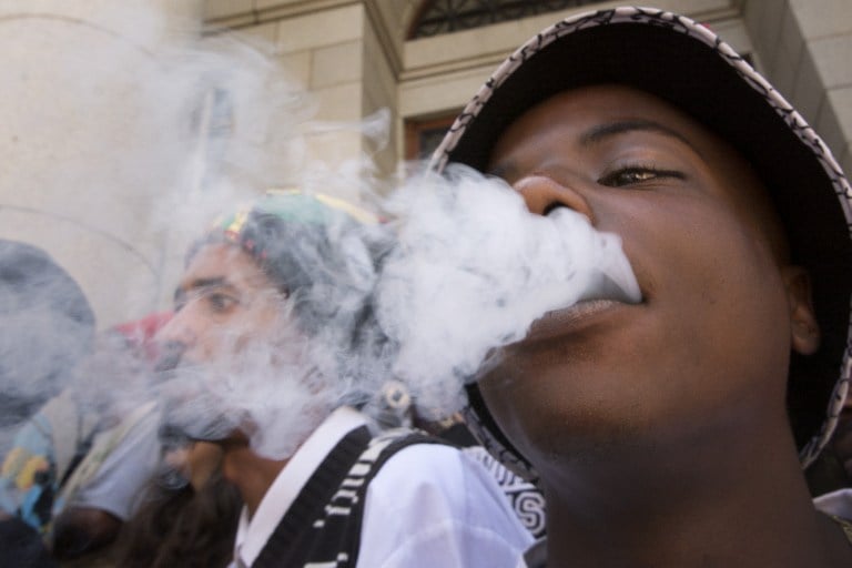 A man smokes a marijuana cigarette outside the Cape Town high court in support of a court application to decriminalise marijuana in December 2015. Photo: AFP/RODGER BOSCH
