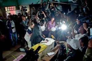 Journalists and polling staff look on as Kenya's then Prime Minister Raila Odinga, casts his vote on March 4, 2013. Photo: AFP/Will Boase