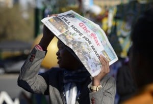 A journalists protects his head from the sun while waiting outside the hospital where South Africa's former president Nelson Mandela was being cared for in June 2013. Photo: AFP/Eric Feferberg