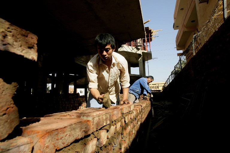 Chinese workers build a wall at a construction site in the capital of Sudan in February 2012. In 2013, the Chinese ministry of commerce reported that more than 2,000 Chinese companies operated on the African continent. Photo: AFP/ASHRAF SHAZLY