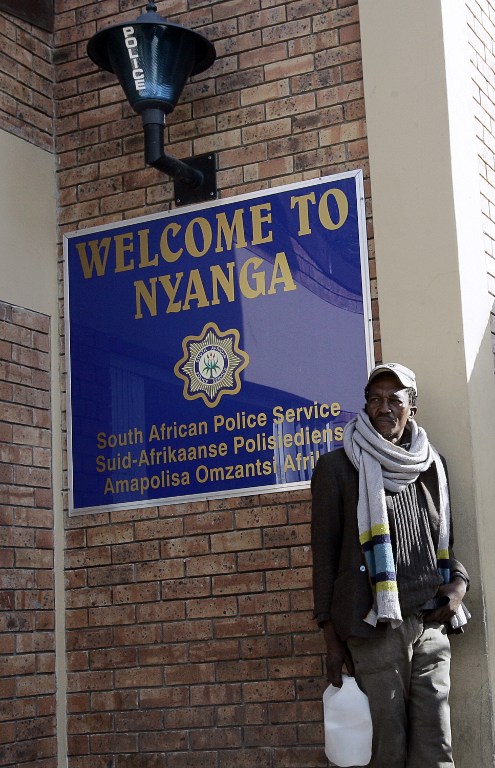 A resident waits outside the Nyanga police station in the City of Cape Town in July 2007. Photo: AFP/GIANLUIGI GUERCIA