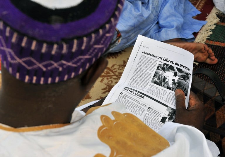 A man reads an article while listening to a statement delivered by Muslim religious leaders in Dakar in April 2009 criticising the release of 9 men allegedly jailed for being homosexual. Photo: AFP/GEORGES GOBET