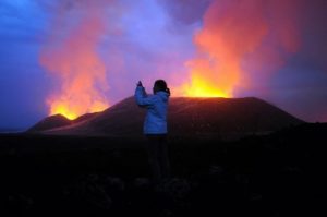 A tourist takes a picture of the eruption of the Nyamulagira volcano in Virunga National Park near Goma in the Democratic Republic of Congo on November 24, 2011.Photo: AFP / Steve Terill
