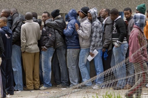 Hundreds of refugees, mostly from other African countries, queue outside the South African Department of Home Affairs to apply for extensions of their asylum seeker permits, and other similar documents, on 20 June 2013 in the centre of Cape Town. Photo: AFP/RODGER BOSCH
