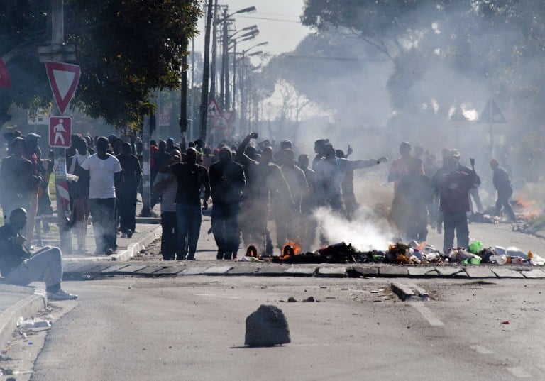 Residents from Langa in Cape Town sing and dance during a protest against housing allocations and other service delivery issues in July 2014. Police closed all routes into the township. Photo: AFP/RODGER BOSCH