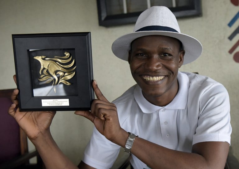 Nigerian Wellington Jighere holds his English-speaking World Scrabble Championships award in November 2015. Photo: AFP/PIUS UTOMI EKPEI
