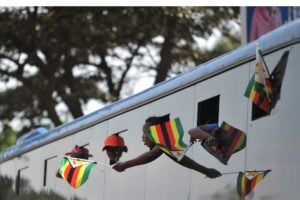 Supporters of Zimbabwe's incoming president Emmerson Mnangagwa, wave Zimbabwean flags from a bus as they arrive at the ruling Zanu-PF party headquarters in Harare on 22 November 2017. Photo: AFP/TONY KARUMBA