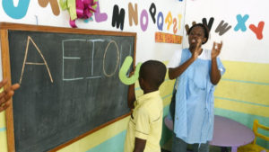 A teacher at the Child Psycho-Social Action Centre in Abidjan applauds a child with autism as he puts letters on a blackboard on 13 April, 2018. Autism remains poorly understood on the continent. Photo : AFP/SIA KAMBOU