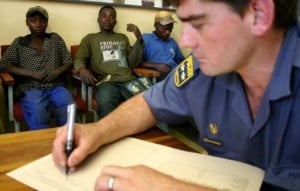 A policeman fills out forms following the detention of three suspects in Welkom, South Africa, 2006. Photo AFP/Fati Moalusi