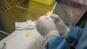 A person holds an experimental vaccine against the AIDS virus in Shoshaguve, near Pretoria, on November 30, 2016 as South Africa launched a major clinical trial of the experimental vaccine, which scientists hope could be the "final nail in the coffin" for the disease. - More than 30 years of efforts to develop an effective vaccine for HIV have not borne fruit, but for the first time since the virus was identified in 1983, scientists think they have found a promising candidate. The new study, known as HVTN 702, will involve more than 5,400 sexually active men and women aged 18-35 in 15 areas around South Africa over four years. (Photo by MUJAHID SAFODIEN / AFP)