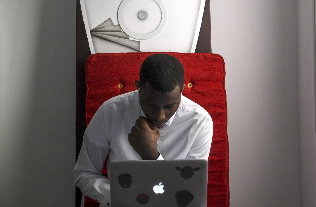 Un homme utilise un ordinateur dans le bureau d'Impact Hub Dakar, une startup spécialisée dans le webdesign, à Dakar, le 16 août 2018. Seyllou / AFP