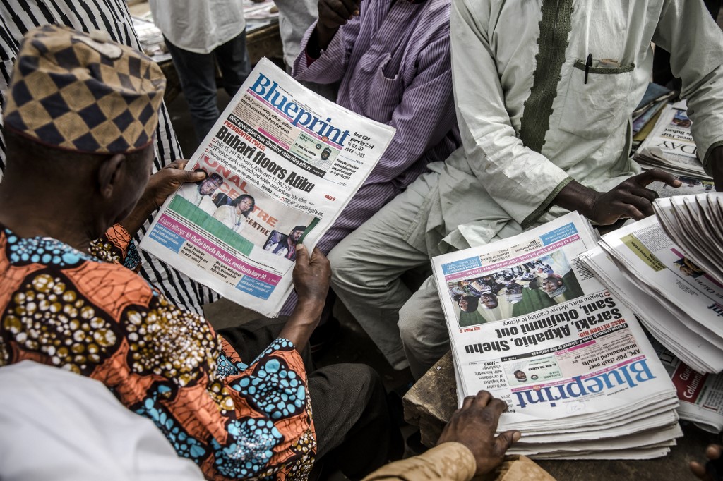 Un homme lit un journal national avec un titre annonçant la victoire du président sortant Muhammadu Buhari, après le résultat de l'élection présidentielle du Nigeria, le 27 février 2019, à Kano. 