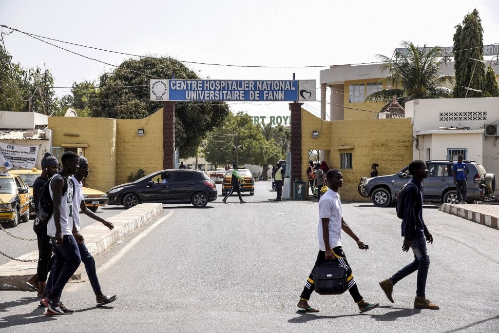 Des piétons passent devant l'entrée du Centre hospitalier national universitaire de Fann, à Dakar, le 2 mars 2020. Seyllou / AFP