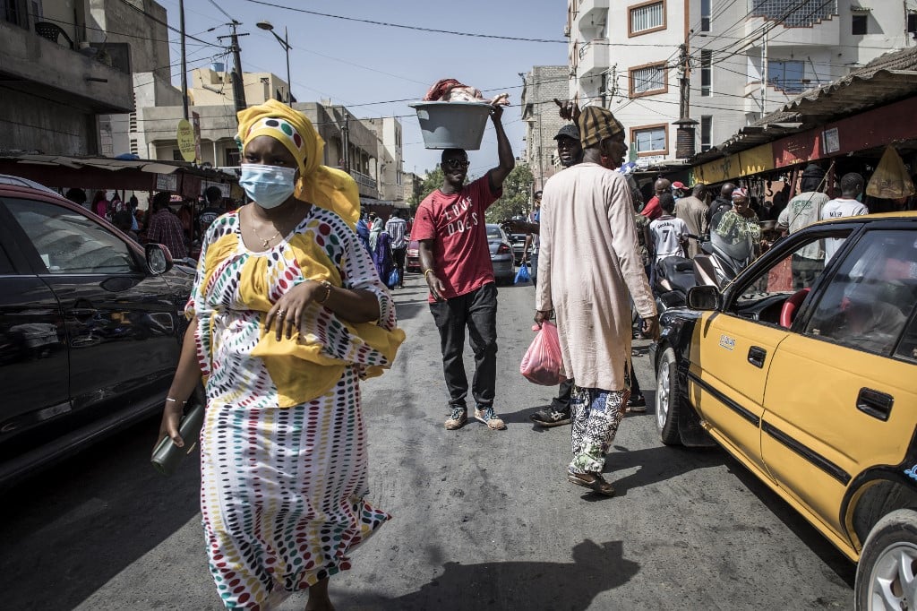 Un homme porte un seau rempli de viande sur un marché à Dakar le 23 mai 2020. 