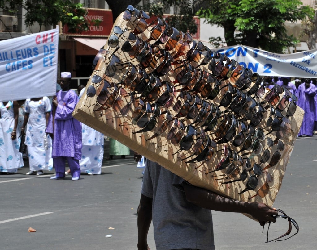 Un vendeur ambulant vend des lunettes dans les rues de Dakar lors d'un rassemblement organisé à l'occasion de a fête du Travail, le 1er mai 2009. Des rassemblements avaient eu lieu dans le monde entier, les organisateurs promettant, partout, de mettre en évidence la colère du public face à la récession paralysante qui a fait perdre leur emploi à des millions de personnes. GEORGES GOBET / AFP