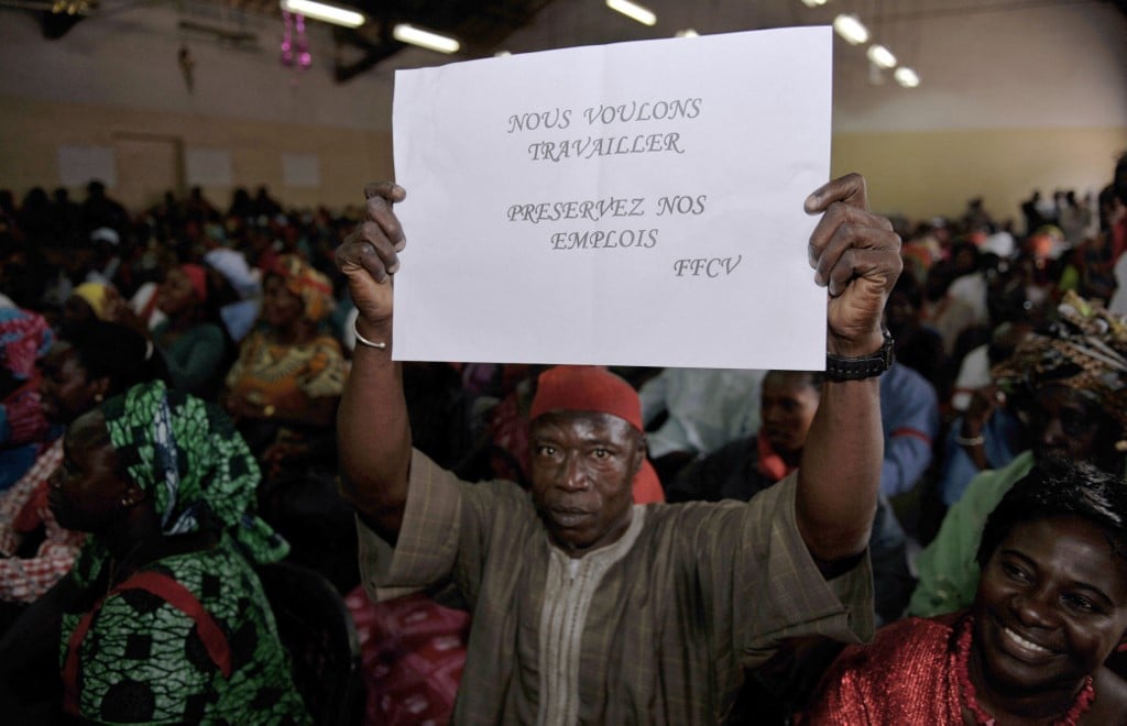 Un homme brandit une pancarte sur laquelle on peut lire « Nous voulons travailler garder nos emplois FFCV », le 11 mars 2010 à Dakar lors d'une réunion des employés sénégalais travaillant dans les bases militaires françaises. FFCV signifie "Forces Françaises du Cap Vert". SEYLLOU DIALLO / AFP
