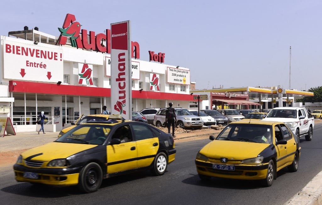 Des voitures passent devant un supermarché du groupe français Auchan, le 24 octobre 2017 dans le quartier de Yoff à Dakar, alors que le groupe français a renforcé sa présence dans la capitale sénégalaise après avoir racheté les magasins City Dia. SEYLLOU