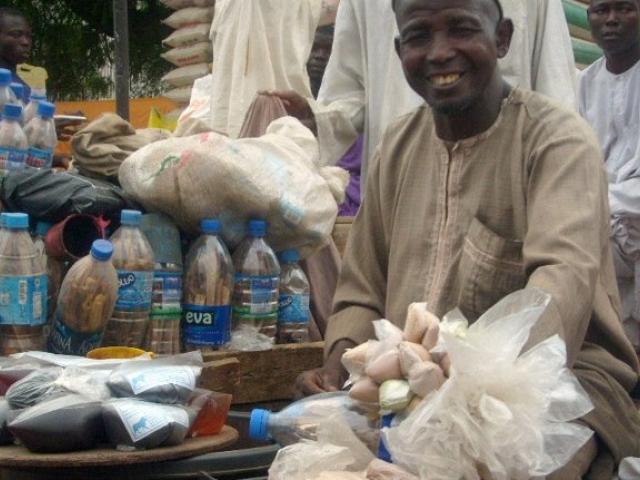 Nigerian herbal market with sellers smiling