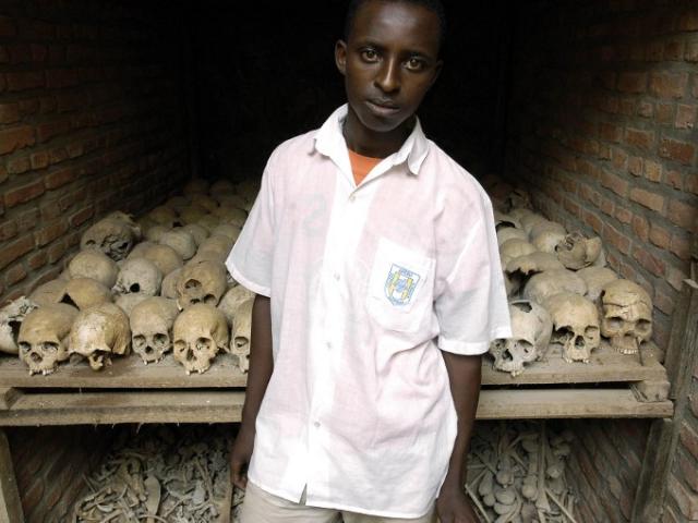 Man standing in front of Rwandan genocide Skulls
