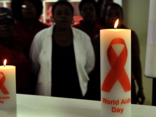 A photo taken in November 2013 shows staff members of the Themba Lethu Clinic in Johannesburg, the largest antiretroviral treatment site in the country, posing behind candles commemorating World Aids Day on December 1. Photo: AFP/Alexander Joe