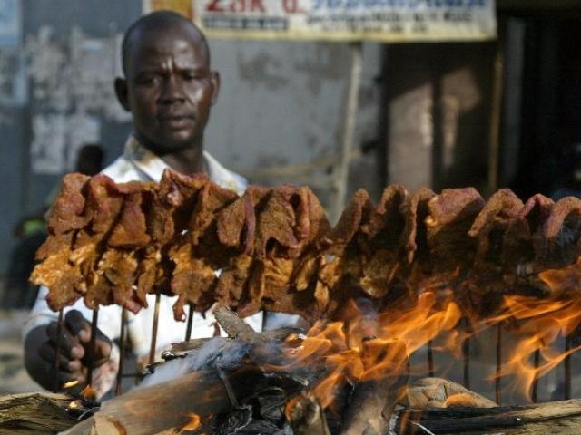 A man arranges sticks of meat - popularly known as suya - on a mud platform for roasting in the ancient city of Kano, Nigeria, in April 2007. Photo: AFP/Pius Utomi Ekpei