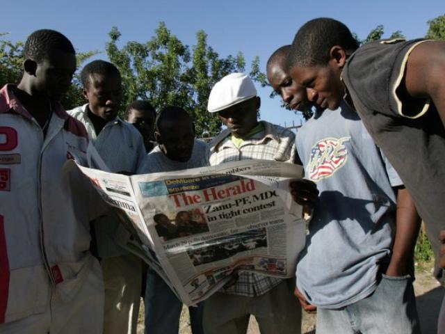 A group of Zimbabwean read a local newspaper in 2008. Photo: Alexander Joe/AFP