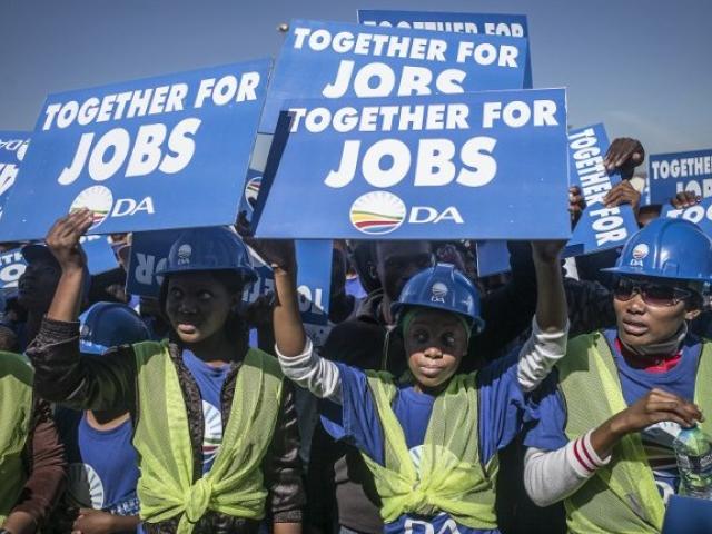 Supporters of the South African opposition party Democratic Alliance (DA) holds signs as they gather in Mamelodi during an election rally in April 2014. Photo: AFP/MARCO LONGARI