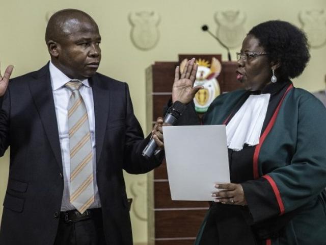 David "Des" van Rooyen raises his hand as he is sworn in by judge Sisi Khampepe as South Africa's new finance minister on 10 December 2015 at the Union Buildings in Pretoria. Photo: AFP/GIANLUIGI GUERCIA