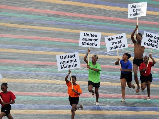 Children run with advertising banners for the fight against malaria during a ceremony held ahead of the 2013 African Cup of Nations final football match Nigeria vs Burkina Faso, on February 10, 2013 in Johannesburg. AFP PHOTO / ALEXANDER JOE / AFP PH