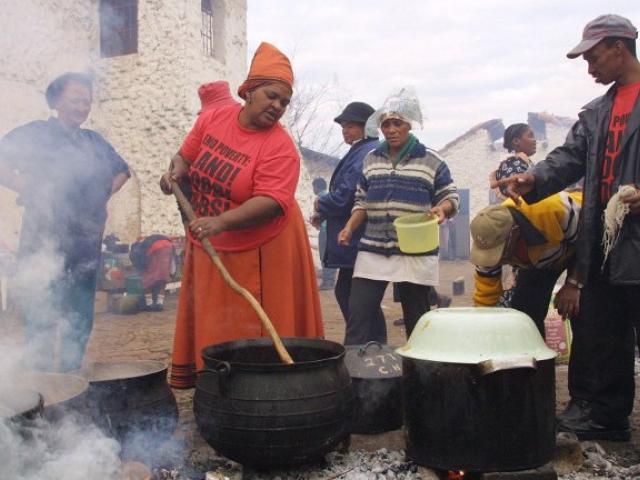 Landless people cook meals at the Landless People's camp near the Nasrec exhibition centre outside Johannesburg in 2002. Photo: AFP/Anna Zieminski