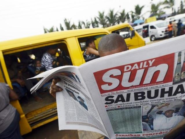 A man in Lagos reads the Sun Daily newspaper announcing the victory of President Muhammadu Buhari on April 1, 2015. Photo: AFP/PIUS UTOMI EKPEI
