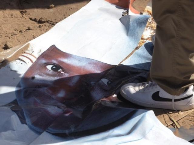 A man walks on a ripped electoral poster of Gambia's president Yahya Jammeh, in a street of Bijilo, on December 4, 2016. Photo: AFP/SEYLLOU
