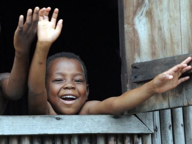 Children wave from the window of a house in the Makoko slum in Lagos in September 2011. Photo: AFP/PIUS UTOMI EKPEI