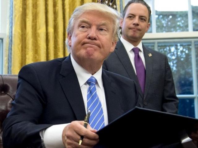 US President Donald Trump signed an executive order reinstating the Mexico City policy in January 2017, while his chief of staff, Reince Priebus, looked on. Photo: AFP/SAUL LOEB