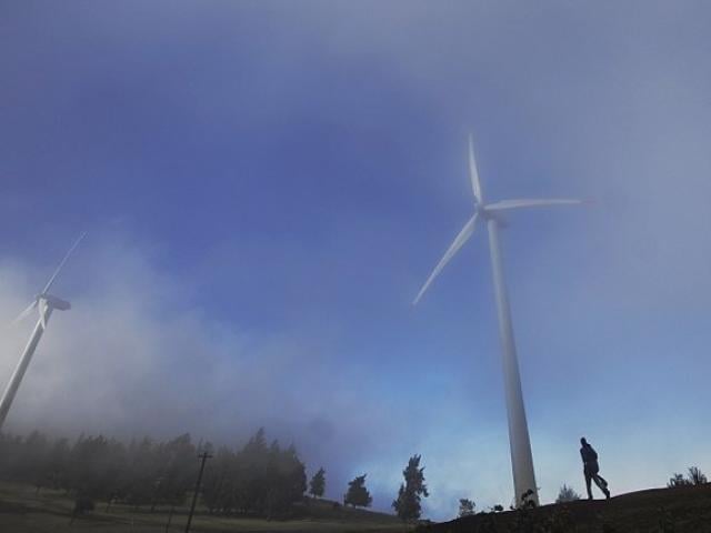 A man walks in the morning mist near wind turbines in the Ngong hills outside Nairobi, Kenya, in October 2010. Photo: AFP/TONY KARUMBA