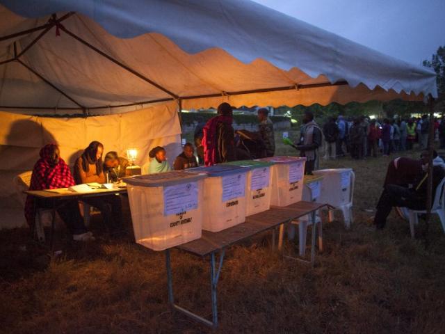 Voters stand in line at dawn to vote at the Manyatta Primary School polling station in west Nairobi in March 2013. Photo: AFP/Georgina Goodwin