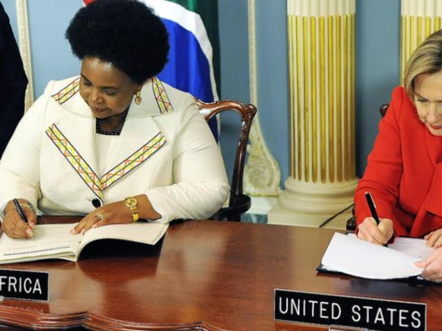 Hillary Clinton, at the time the US secretary of state, and former South African foreign affairs minister Maite Nkoana-Mashabane sign the PEPFAR Partnership Framework Agreement with in the Treaty Room at the US Department of State in Washington, DC o