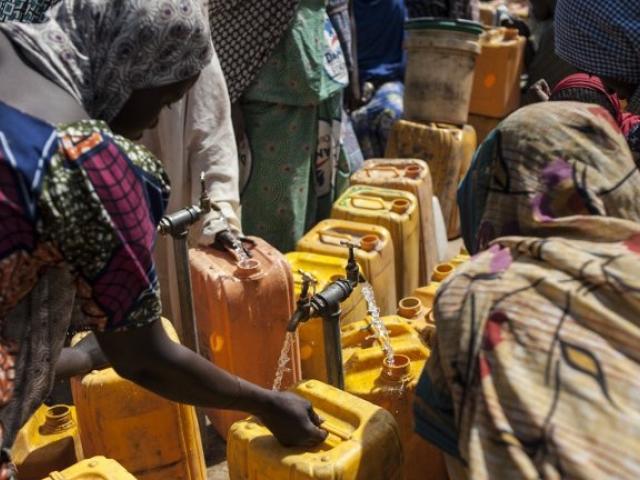 Women collect water in a camp for internally displaced people in Bama, Nigeria, in December 2016. Photo: STEFAN HEUNIS