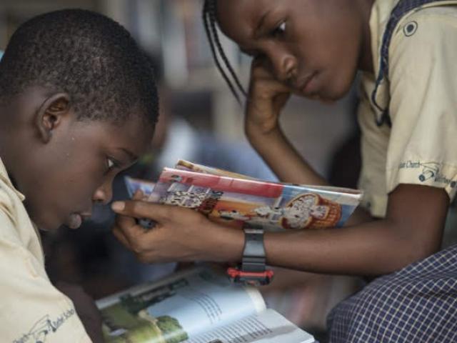 A boy and a girl sit and read books in the I-Read mobile library on 30 January 30 2018, in Lagos.The 'mobile library' project was launched in 2013 by Funmi Ilori. Today, she has 13 employees, 1,900 books and four vans. She visits four to six schools 