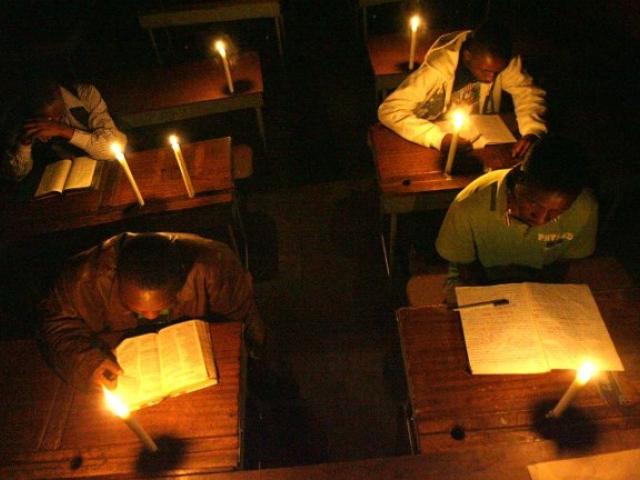 Night school students study by candlelight after a power cut in Harare's Mabvuku suburb in November 2010. Photo: AFP/DESMOND KWANDE