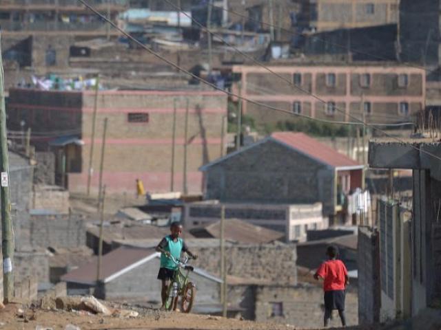 Children play on a ridge against a backdrop of housing blocks in the Baba-Dogo area of Nairobi in January 2017. Officials estimate Kenya's housing shortage at 2 million homes. Photo: AFP/ TONY KARUMBA