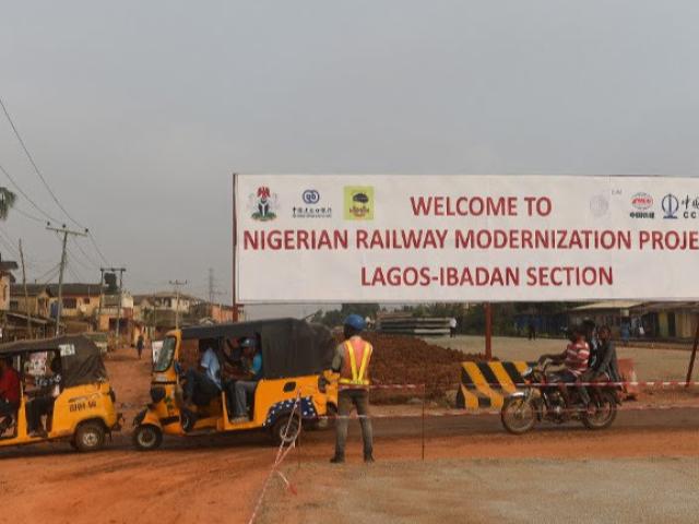 Rickshaws drive past the standard gauge railway line under construction from Lagos to Ogun State in February 2019. The train is expected to boost the economy and reduce congestion in the economic nerve centre. Photo: AFP/PIUS UTOMI EKPEI