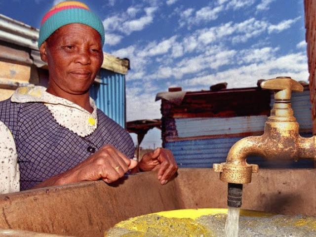 Ms Anna Jacobs fills her bucket with water from a tap placed by the government next to her house in this April 1999 file picture. As the world marks World Water Day on 22 March, for many in Africa, water access remains a key challenge. Photo: ODD AND