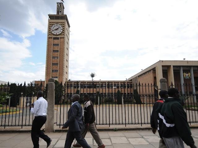 Kenyans walk past the parliament building in Nairobi in this 2013 photo. Legislators play a key role in revenue allocation. Photo: AFP/ SIMON MAINA
