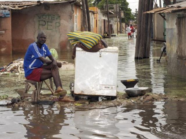 Un homme devant sa maison dans un quartier inondé de la banlieue dakaroise en 2009. Photo AFP