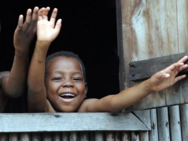 Des enfants faisant un signe de la main à partir de la fenêtre d’une maison à Makoko, un quartier pauvre de Lagos, en septembre 2011. Photo AFP