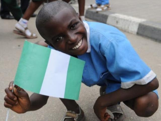 Un élève brandit le drapeau nigérian pour accueillir l'équipe nationale de football à l'aéroport d'Abuja le 12 février 2013. Les étudiants nigérians ont une longue tradition d'aller aux États-Unis pour suivre des études supérieures. Photo