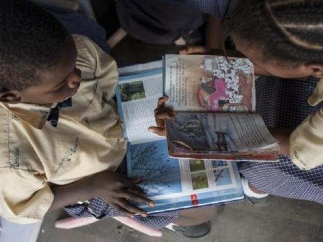 Un garçon et une fille en train de lire dans une bibliothèque mobile au Nigéria en janvier 2018. Photo : AFP.