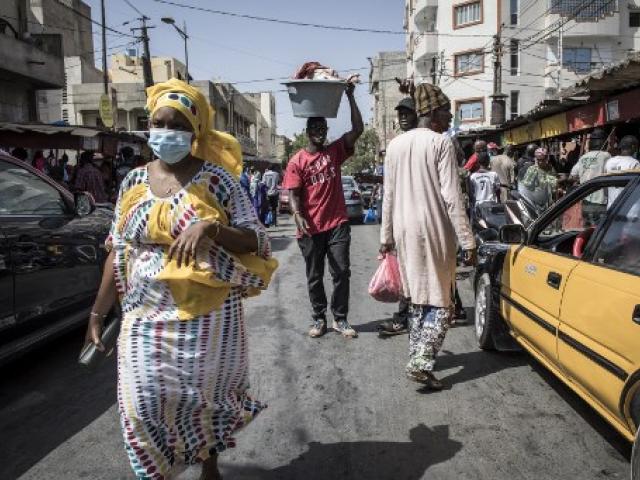 Un homme porte un seau rempli de viande dans un marché de Dakar, le 23 mai 2020, alors que les habitants font leurs courses à la veille de la fête de la Korite qui marque la fin du mois sacré musulman du Ramadan.  JOHN WESSELS / AFP