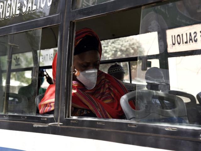 Un passager porte un masque facial dans un bus à Dakar, le 20 avril 2020, après que le ministère de l'Intérieur a annoncé le 19 avril 2020 l'instauration du port obligatoire de masques dans les services publics et privés, les commerces et les transports, sous peine de sanctions. Seyllou / AFP